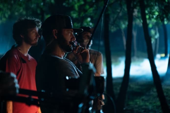 An Assistant Director coordinating a night shoot over a walkie-talkie