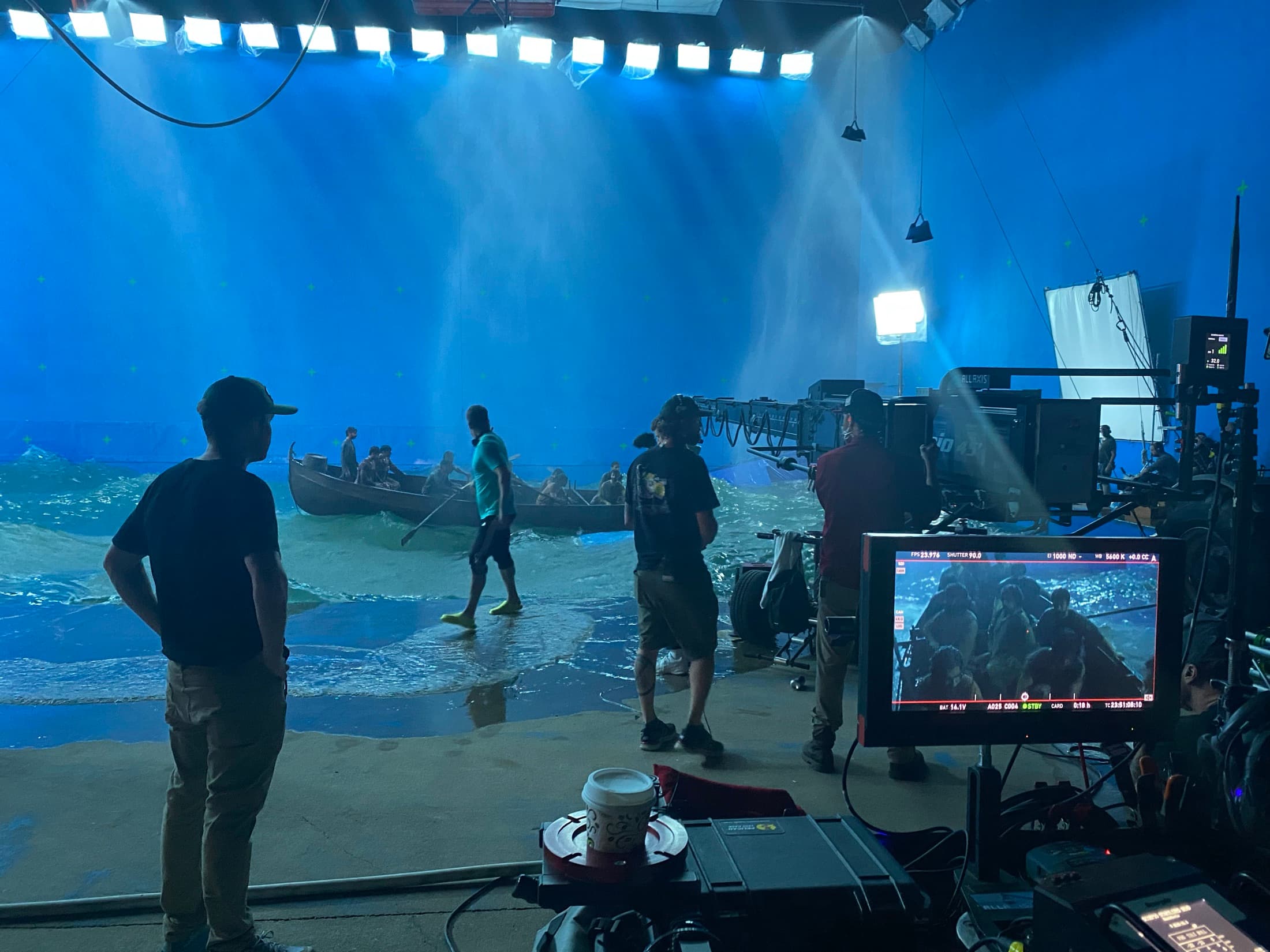 A film crew operating a camera crane on a water stage